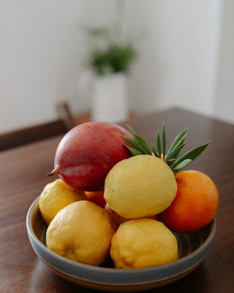 Schale mit Zitrusfrüchten und Granatapfel auf einem Tisch
